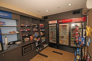 A self-service snack and beverage station with refrigerated and non-refrigerated options, including a variety of snacks and drinks. - Candlewood Suites Newport News/Yorktown by IHG (Yorktown)