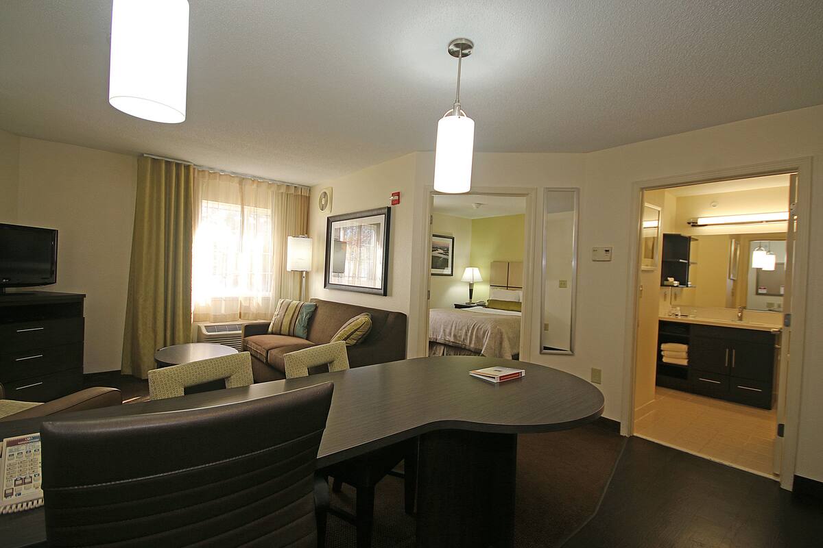 Une chambre d’hôtel comprenant un coin repas, une télévision, un lit et une salle de bain.