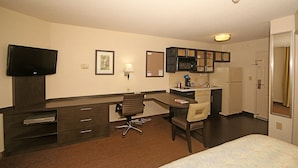 A hotel room with a desk, chair, television, and a bed. - Candlewood Suites Newport News/Yorktown by IHG (Yorktown)