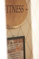 Un cartello con la scritta 'FITNESS' e un poster informativo incorniciato sotto.