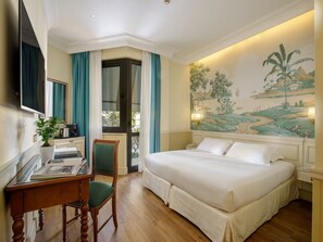 A hotel room with a large bed, a desk with a chair, a television, and a balcony with curtains. - Donna Laura Palace by OMNIA hotels (Rome)