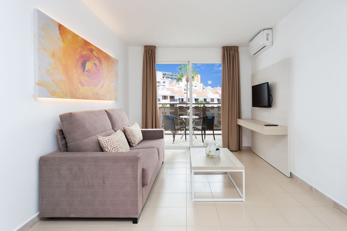 A modern living room with a sofa, coffee table, and artwork on the wall.