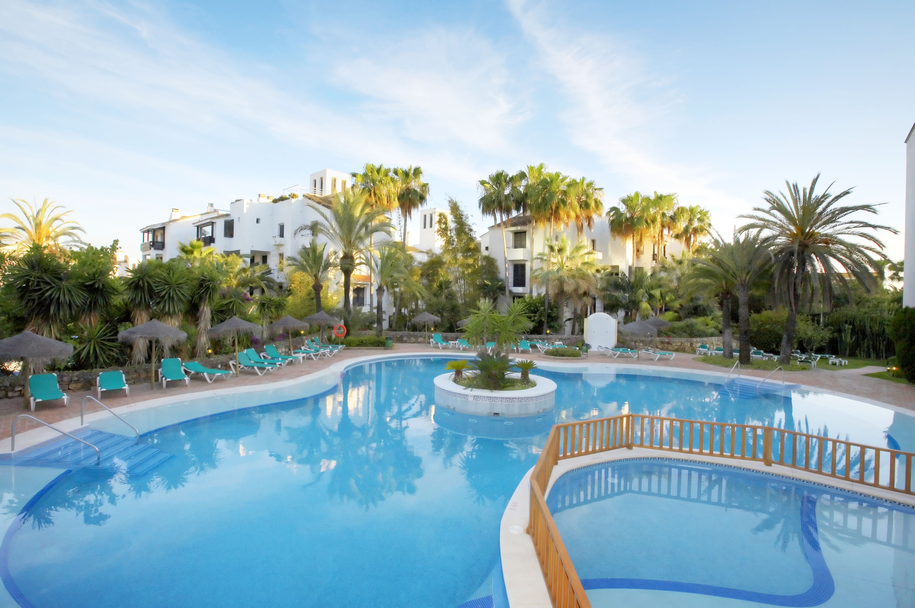 Alberca techada, 3 albercas al aire libre y sombrillas en la alberca