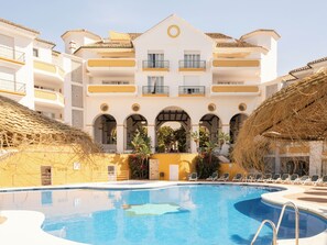 A hotel with a swimming pool, multiple balconies, and a central courtyard with arches. - Ona Alanda Club Marbella (Marbella)