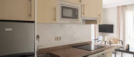 A modern kitchen with a built-in microwave, dishwasher, and granite countertop.