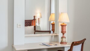 A hotel room with a bed, bedside table, lamp, and a mirror reflecting the room. - Ona Alanda Club Marbella (Marbella)