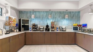 A modern kitchen with a central island, built-in appliances, and a tiled backsplash. - Best Western Executive Inn (Seagoville)