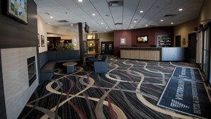 A hotel lobby with seating areas, a reception desk, and a patterned carpet. - Victoria Inn Hotel & Convention Centre Brandon (Brandon)