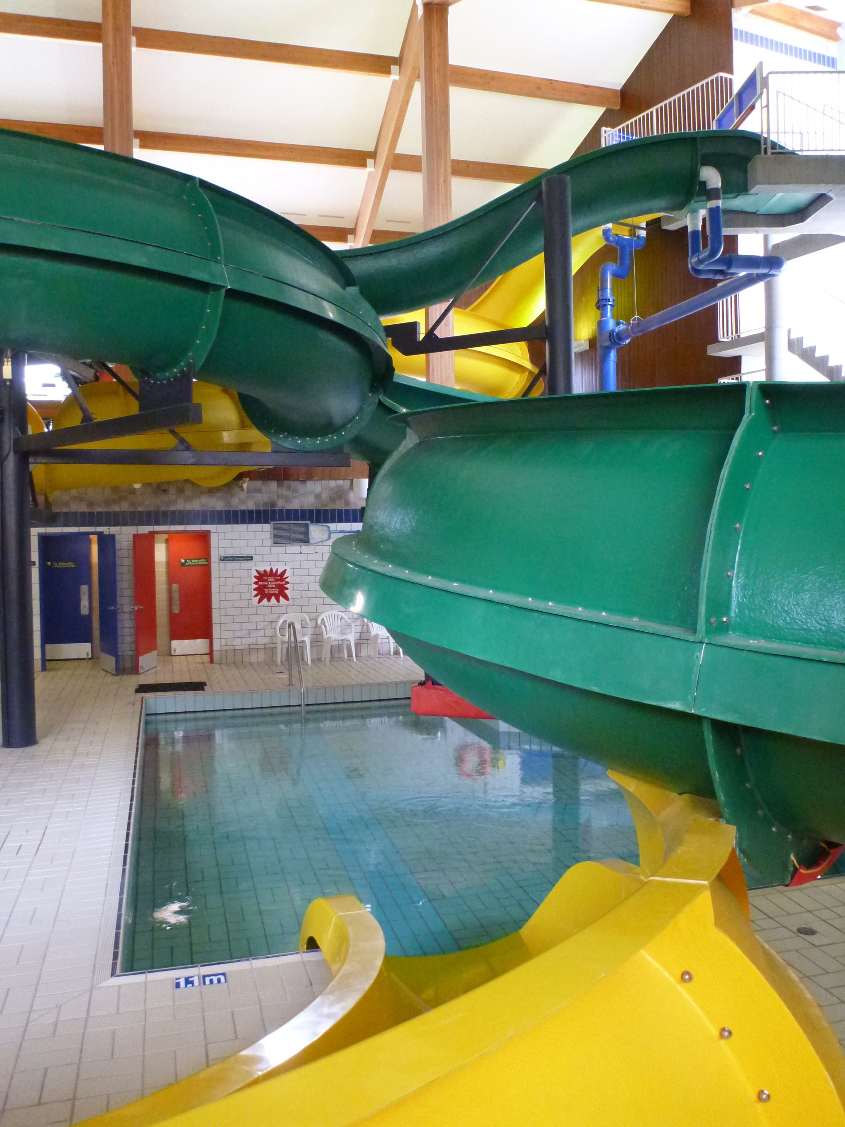 An indoor water park with multiple slides and a pool area.