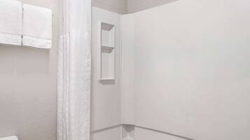 A bathroom with a toilet, a shower, and a towel rack.
