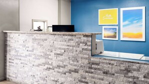 A reception area with a stone counter, a blue wall, and framed pictures including 'Hello Sunshine'.