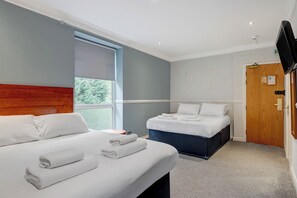Habitación cuádruple estándar | Escritorio, tabla de planchar con plancha, cunas y camas extra 