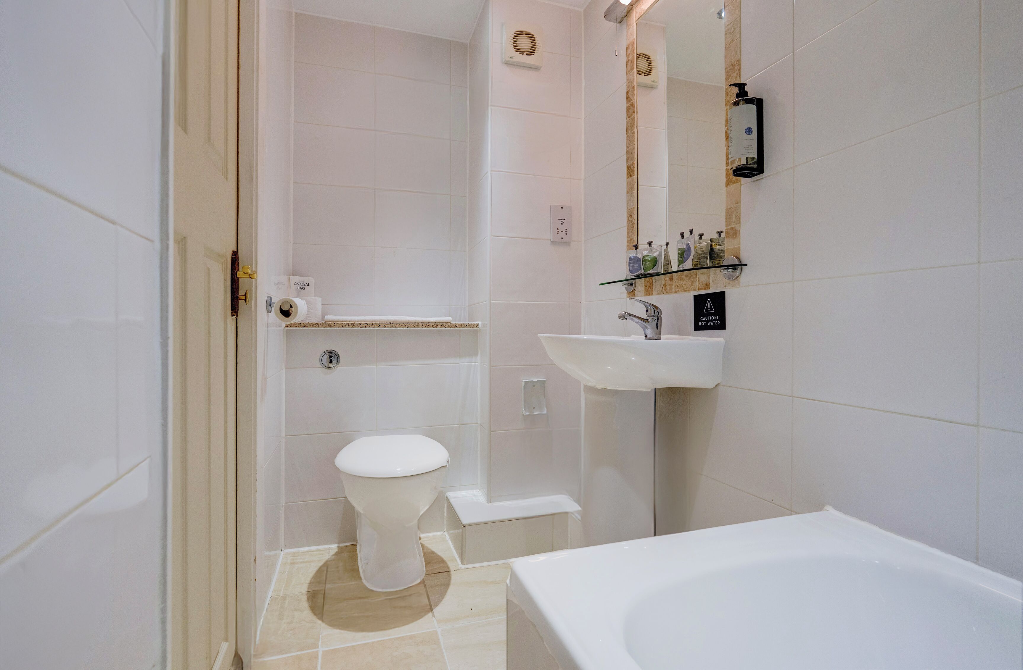 A modern bathroom with a toilet, sink, and bathtub.