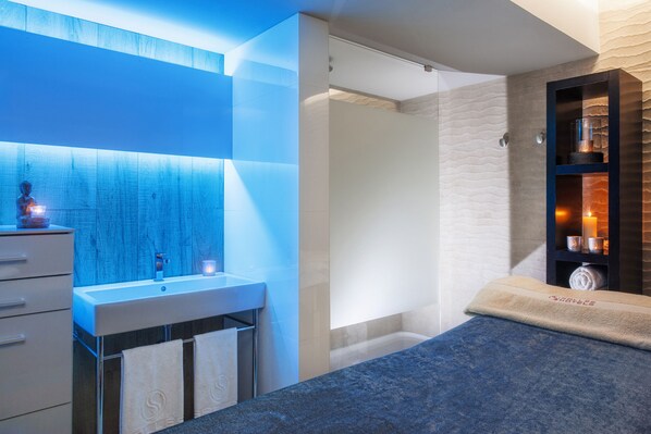 Un baño moderno con un espejo grande, un lavabo y una ducha.