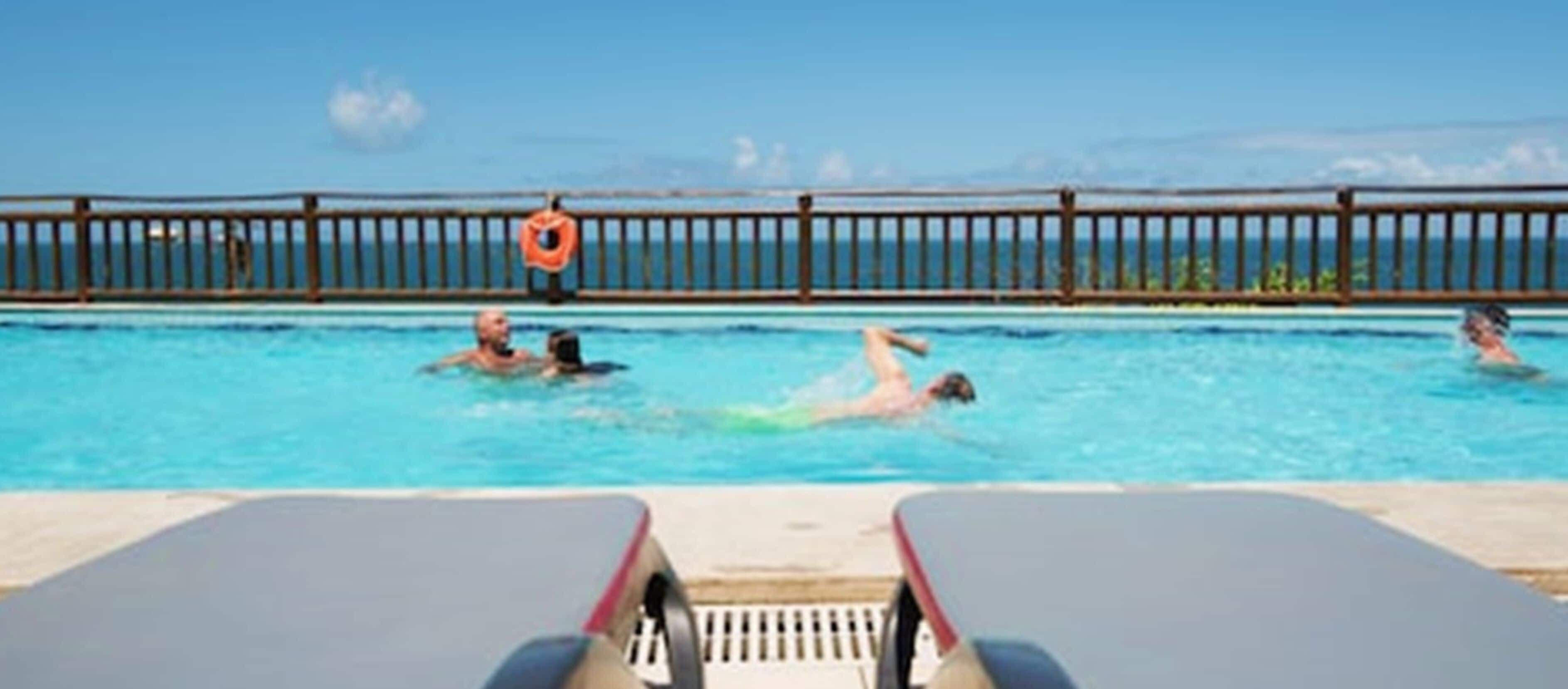 outdoor pool, open 8:00 am to 6:00 pm, pool umbrellas, pool loungers