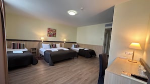 A hotel room with two beds, a desk, a chair, a lamp, and a painting on the wall. - City Gate Hotel (Vilnius)