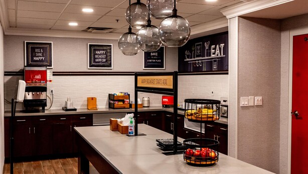 Cozinha moderna com ilha central, cafeteira e apresentação de frutas.