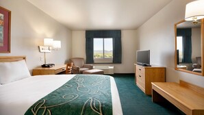 A hotel room with a bed, a desk, a chair, a television, and a large window. - Travelodge by Wyndham Milford (Milford)