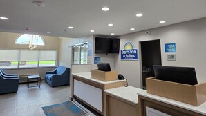 Ein Hotel-Rezeptionsbereich mit Schreibtisch, Stühlen, Brandmelder, Fernseher und einem Schild für Days Inn & Suites.