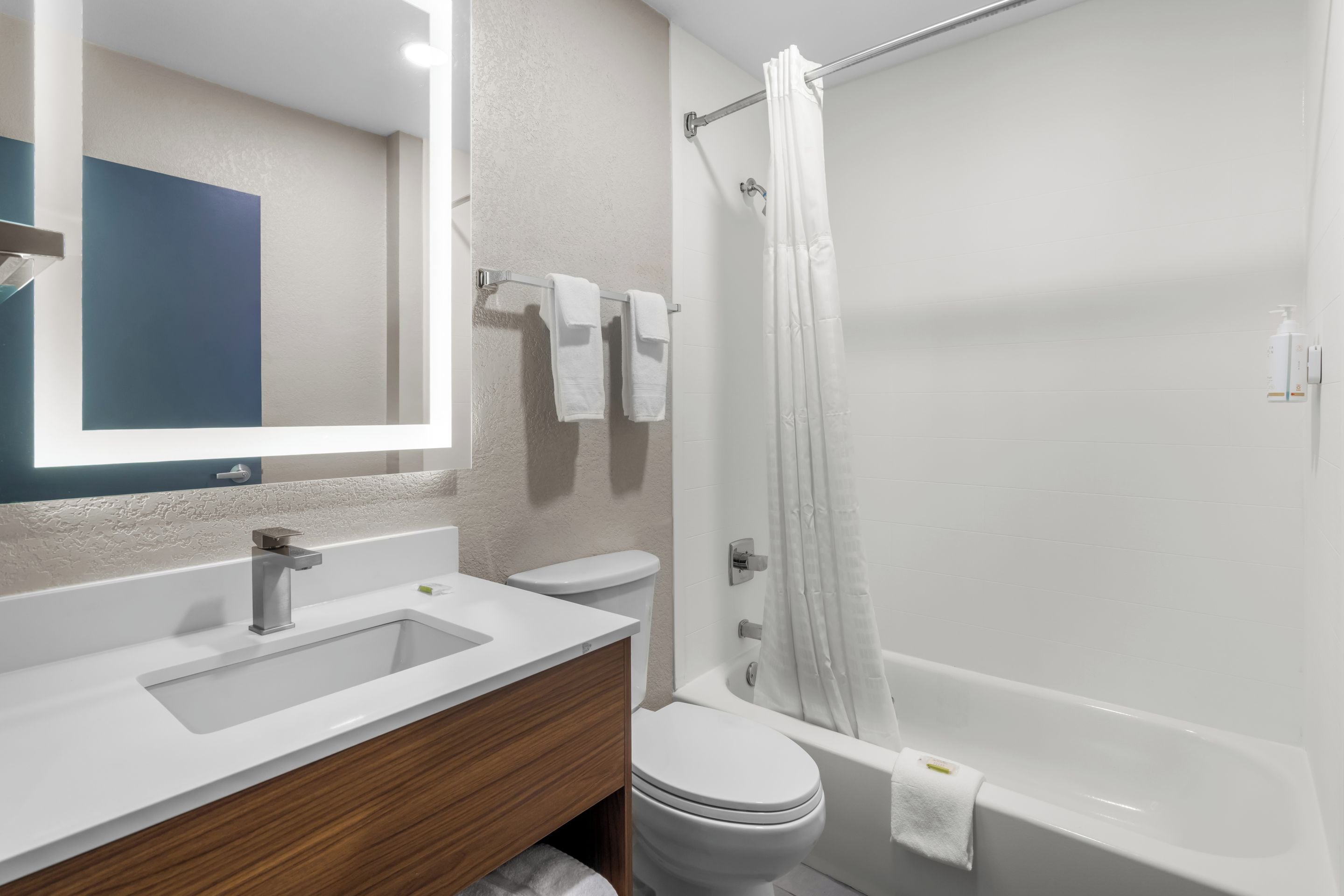 A modern bathroom with a white sink, toilet, and bathtub.