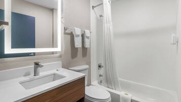 A modern bathroom with a white sink, toilet, and bathtub.
