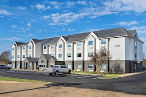 A multi-story hotel with a parking lot and a white pickup truck parked in front. - Days Inn & Suites by Wyndham Brandon Amphitheater (Brandon)