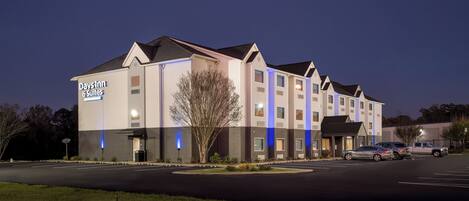 Un hôtel avec une enseigne indiquant « Days Inn & Suites » et un parking rempli de voitures.