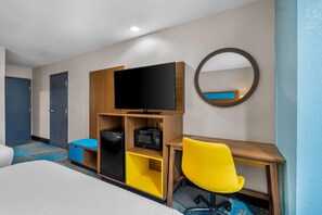A hotel room with a bed, a desk with a chair, a television, a microwave, and a wardrobe. - Days Inn & Suites by Wyndham Brandon Amphitheater (Brandon)