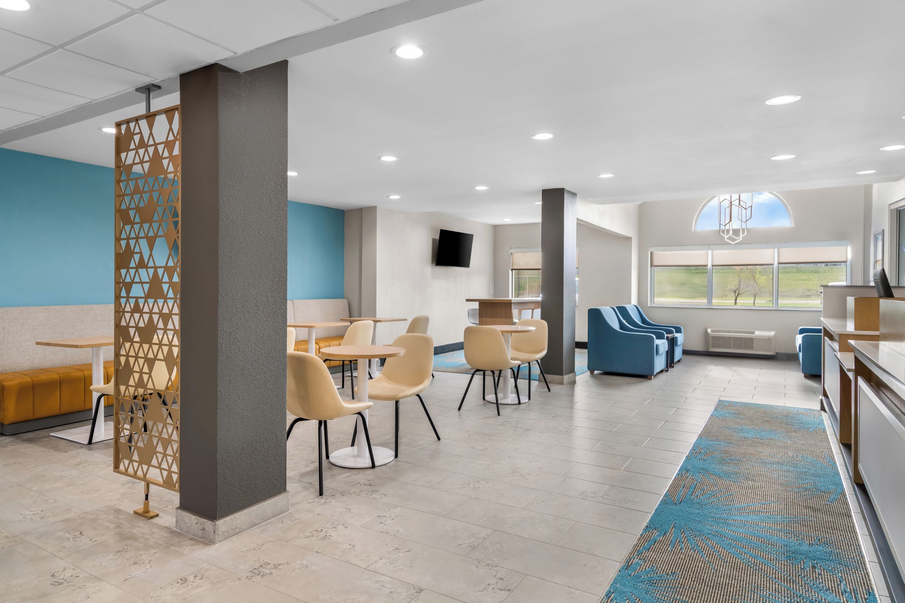 A modern interior with a seating area, tables, and a view of the outdoors.