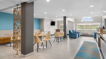 A modern interior with a seating area, tables, and a view of the outdoors.