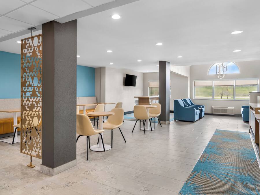 A modern interior with a seating area, tables, and a view of the outdoors.