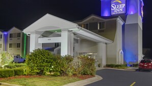 Un hotel Sleep Inn con un diseño moderno, que presenta un letrero llamativo y una entrada cubierta.