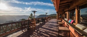 A terrace with wooden furniture and a view of mountains. - Hotel El Mirador by Balderrama Hotel Collection  (Urique)