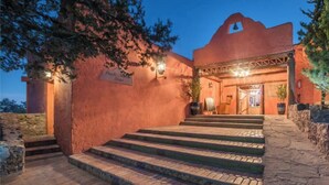 Un edificio con facciata rossa, un cartello che indica un ristorante e una scala che conduce all'ingresso.