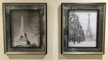 Dos cuadros con imágenes de la Torre Eiffel, uno con flores de cerezo y otro con nieve.