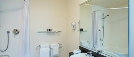A modern bathroom with a bathtub, a sink, and a large mirror.