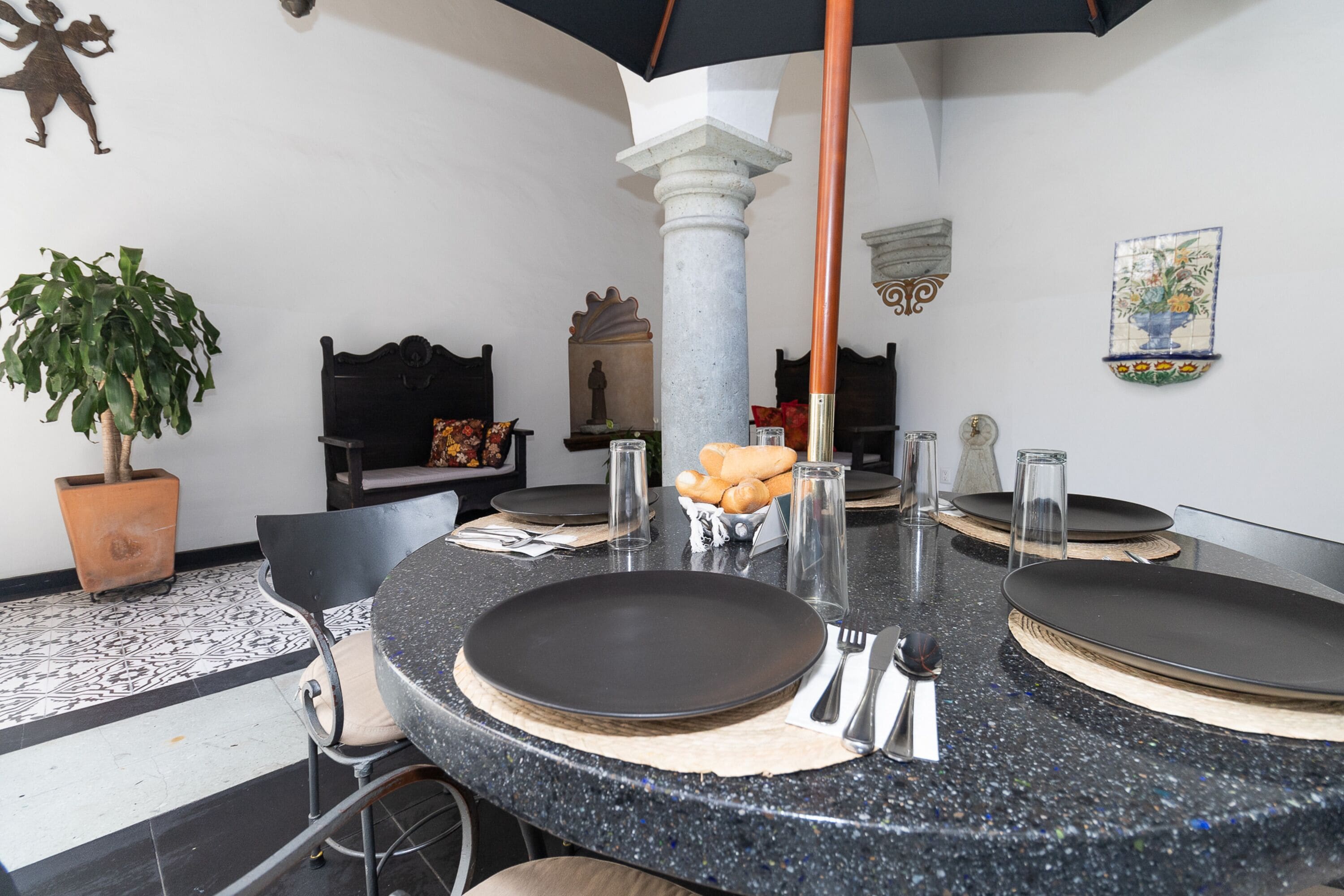 A dining area with a round table set for four, including plates, cutlery, and glasses.