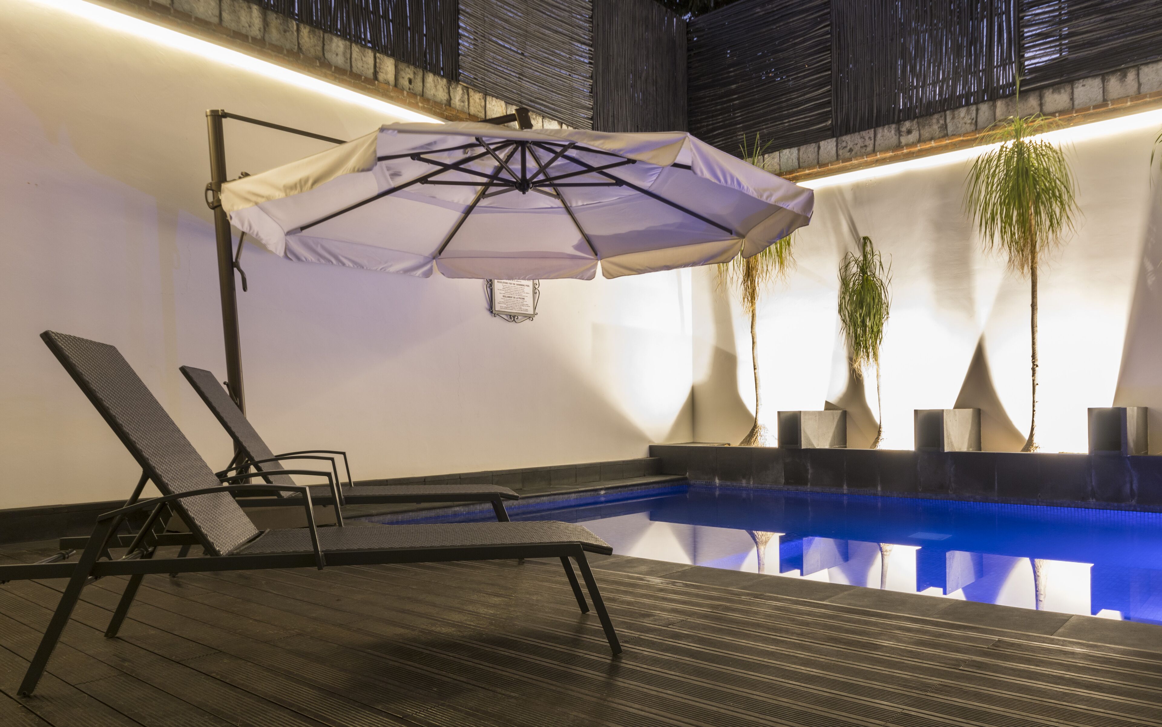 A poolside area with lounge chairs and a canopy umbrella.
