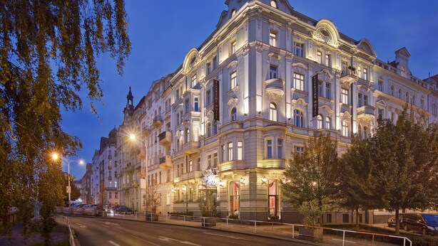 A historic building with ornate architecture, multiple balconies, and illuminated windows.