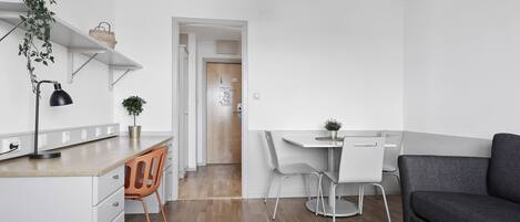 A modern kitchen with white cabinetry, a wooden countertop, and a dining area with a white table and chairs.