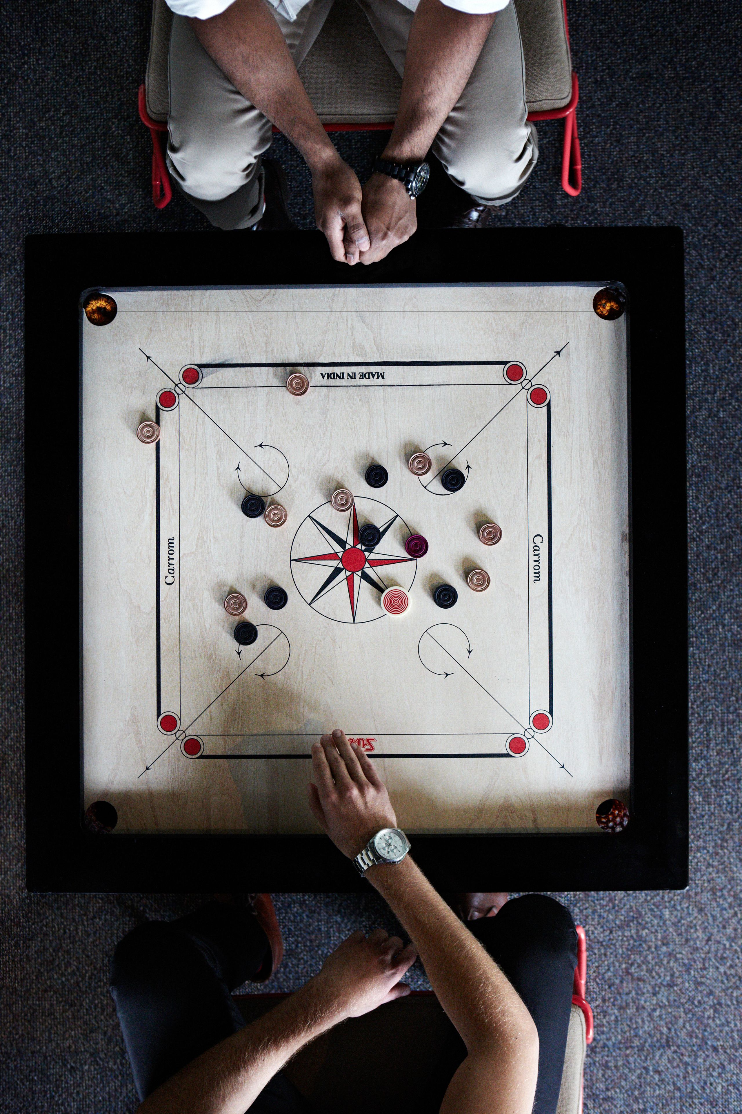 A foosball table with players seated opposite each other, a table tennis table, and a pool table.