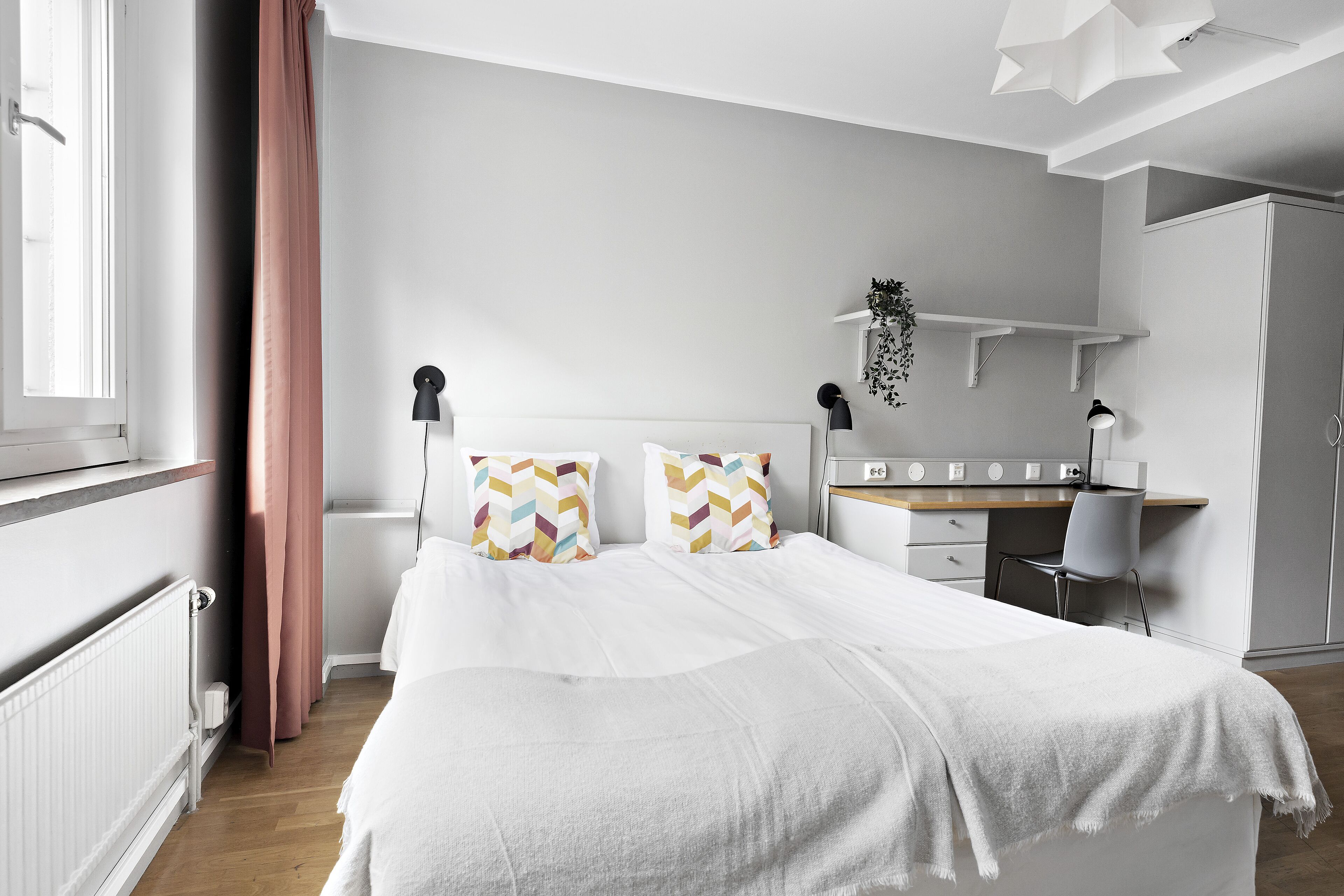 A modern bedroom with a bed, a desk, and a chair.