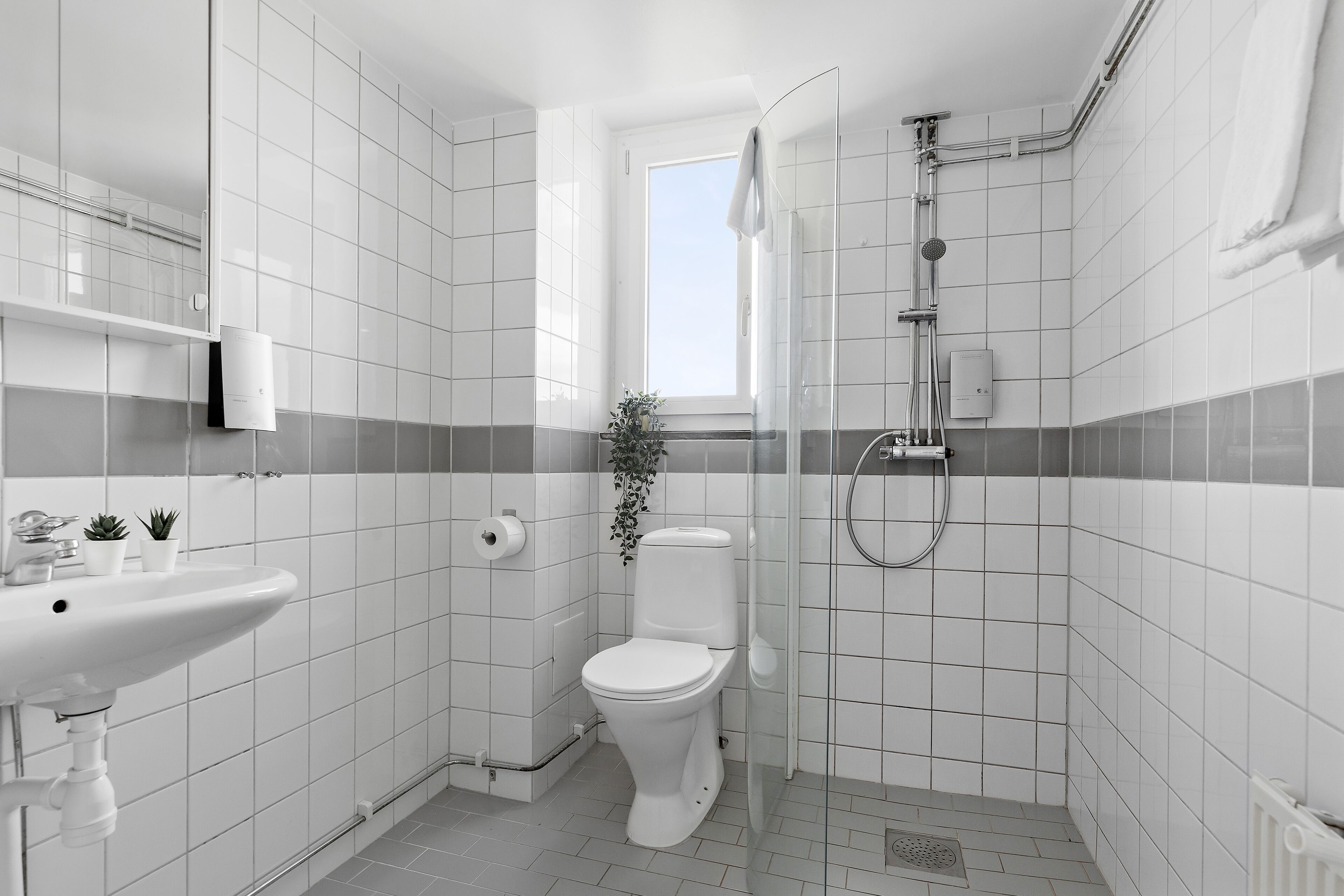 A modern bathroom with a toilet, sink, and shower.