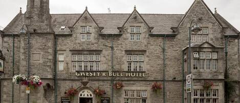 Un edificio de piedra con el letrero "Gwesti'r Bull Hotel".