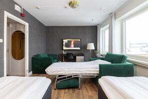 Enjoy city views from the large window, relax on two single beds with green headboards, and work at the desk with a chair.