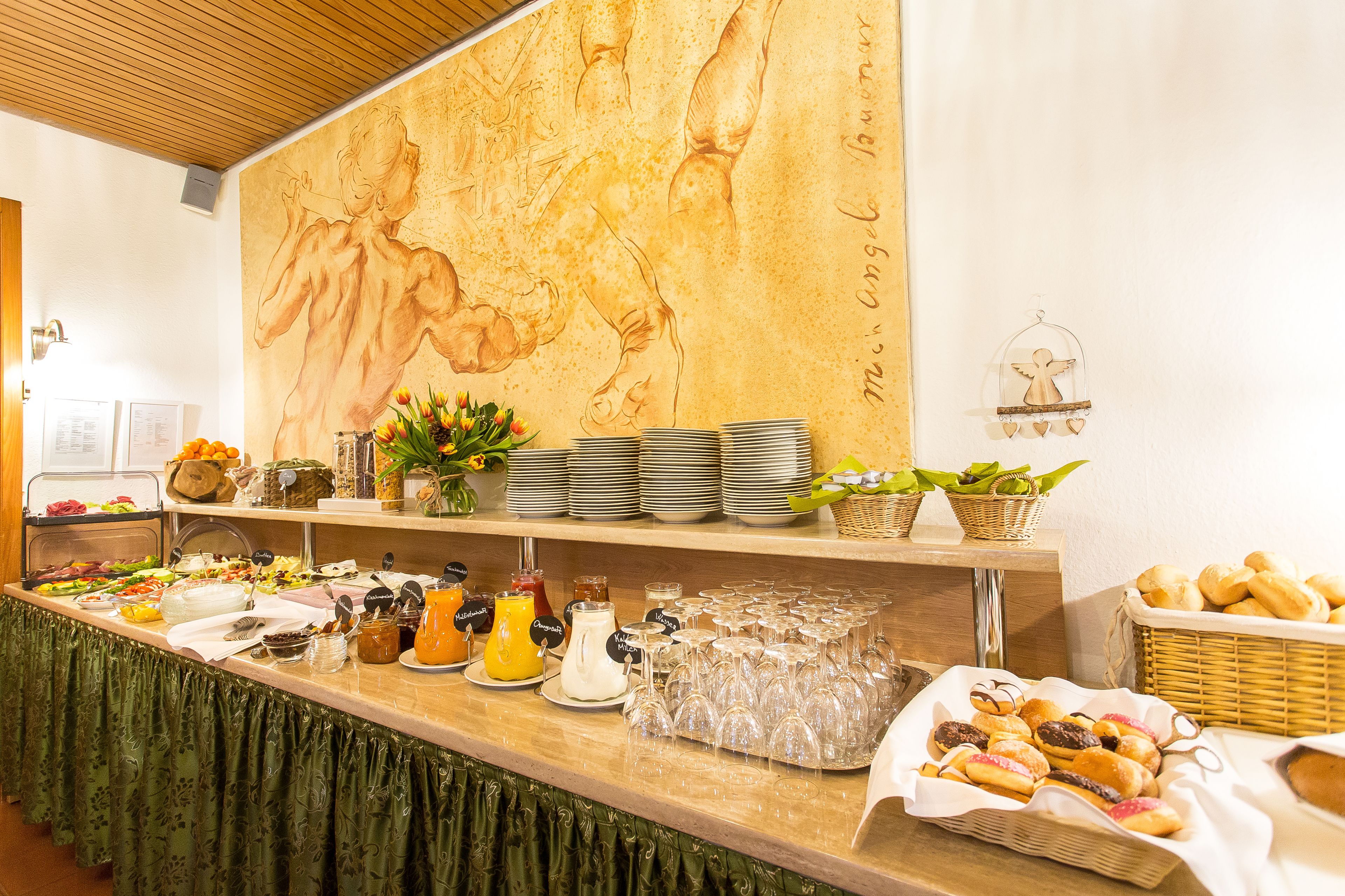 A buffet setup with various food items, plates, and glassware.
