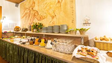 A buffet setup with various food items, plates, and glassware.