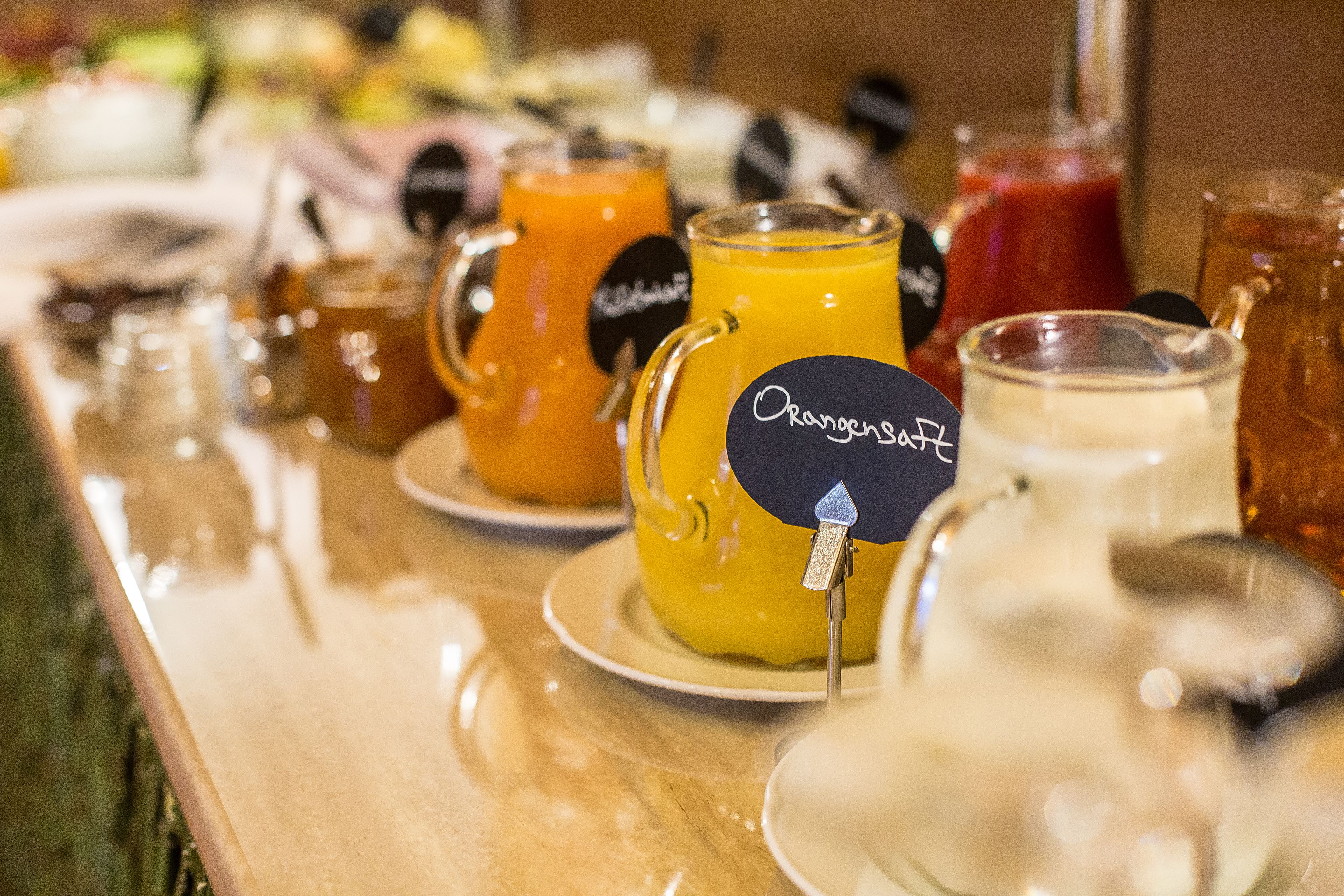 A buffet table with various beverages and dishes.