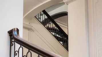A staircase with a black metal railing and beige carpeted steps.