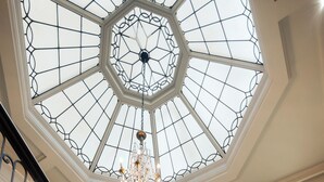 A grand staircase with a glass ceiling and a chandelier. - Grand Hotel Terminus (Bergen)